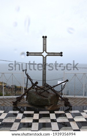 Crimea, Yalta autumn 2019. Near the Temple-lighthouse of Nicholas the Wonderworker, a monument to the fallen sailors, a cross and an anchor are erected. It's raining outside, cloudy. Editorial license
