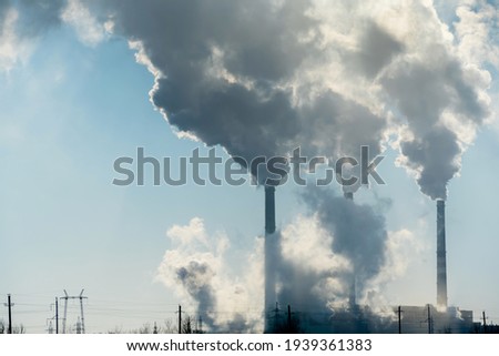 Smoking factory chimneys.Environmental problem of pollution of environment and air in large cities.Climate change,ecology and global warming.The sky is smoky with toxic substances.Soot from factories Royalty-Free Stock Photo #1939361383