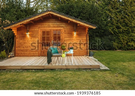 Wooden hut in spring. Drink tea in the garden when the weather is nice. Garden shed for vacation. Nice garden in Germany.  Royalty-Free Stock Photo #1939376185
