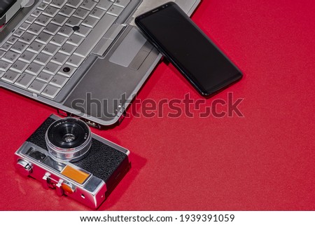 Laptop, photo camera, mobile, on a red background.