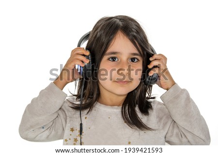 Little girl taking off the headset while looking into the camera