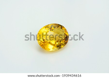 Natural yellow brazilian citrine quartz oval checker faceted gemstone. Unheated, clean, transparent, sparkling, shiny on white backgound. Semiprecious gemstone setting for big solitaire rings. Royalty-Free Stock Photo #1939434616