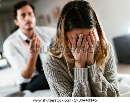 Boyfriend and girlfriend are arguing at home. Angry man is yelling at his sad girlfriend. Royalty-Free Stock Photo #1939448146