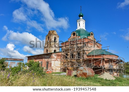 part of a restored church with a new dome against a cloudy sky, surrounded by greenery, close-up  Royalty-Free Stock Photo #1939457548