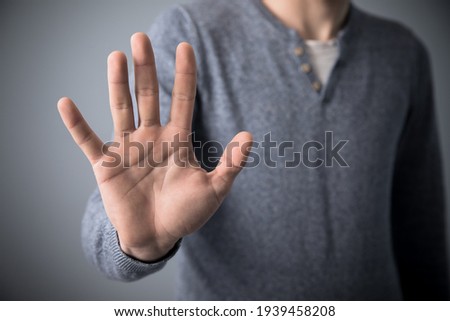 Man making stop sign on grey background
