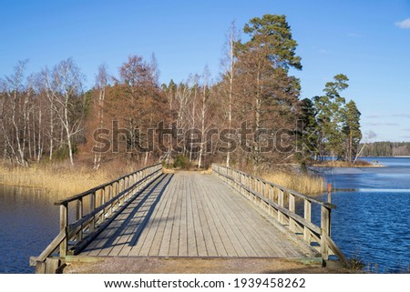 Sunny spring day and bridge over lake in Katrineholm Sweden. Beautiful scandinavian nature and landscape. Calm, peaceful photo.