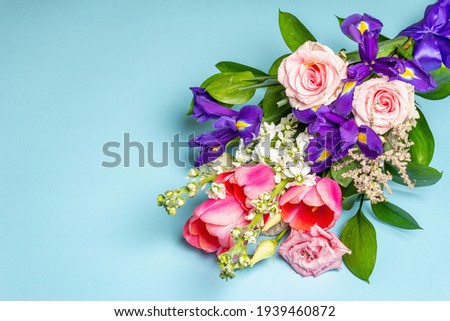 A beautiful bouquet of fresh flowers on a blue pastel background. The festive concept for Weddings, Birthdays, Mother's Day, For Valentine, or March 8th. Greeting card, a place for text, flat lay