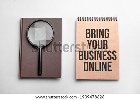 Craft colour notepad with text BRING YOUR BUSINESS ONLINE. Notepad with , magnifying glass. Business concept