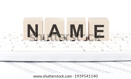NAME -word wooden block on the keyboard background witn chart