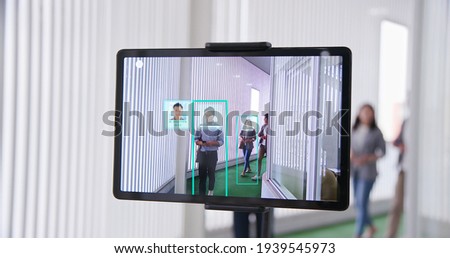 Asian business people pass through a thermal temperature measurement device with individual identification and enter the office   Royalty-Free Stock Photo #1939545973