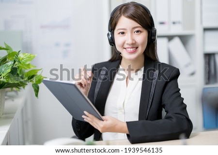 asian customer service representative work and smile at you in the office Royalty-Free Stock Photo #1939546135