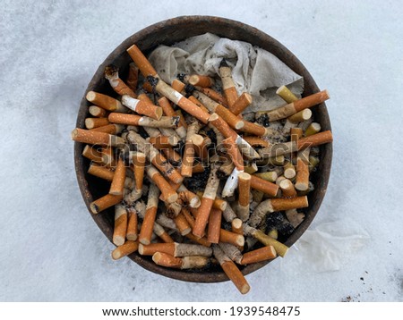 full bucket of cigarette butts close up.