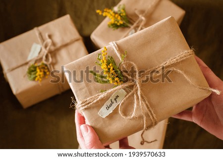 female hands holding gift boxes decorated with yellow flowers a thank you. Appreciate Concept. top view. High quality photo Royalty-Free Stock Photo #1939570633