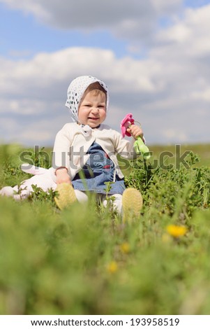 amazing girl sitting in grass with toy flower