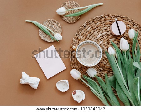 Spring composition. White tulips, coffee cup, candle on brown background. Mother day, 8 march. Blank greeting card. Flat Lay 