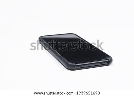 Smartphone on a white background. Photo of a side view of a black smartphone lying on a white background. Smartphone in a protective case.