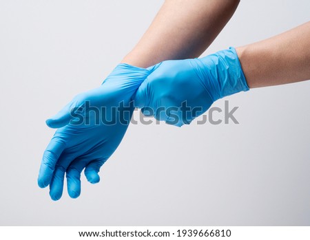 Two hands of a man wearing nitrile gloves on a white background Royalty-Free Stock Photo #1939666810