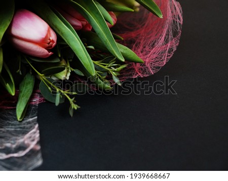 bouquet of delicate tulips on a black background, copy space