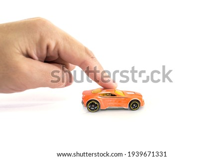 Hand with toy car isolated on white background