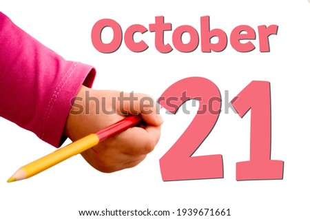 Children's hand writes October 21 in red pencil on white background. Business and holiday concept