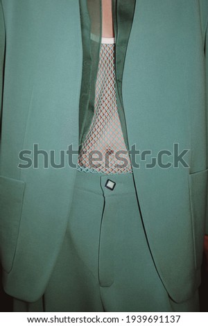 Cropped figure of man in stylish modern fashion green suit