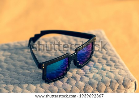 Pixel sunglasses model with blue lenses and black frame closeup in a sunny day. Selective focus