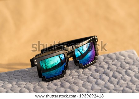 Pixel sunglasses model with blue lenses and black frame closeup in a sunny day. Selective focus