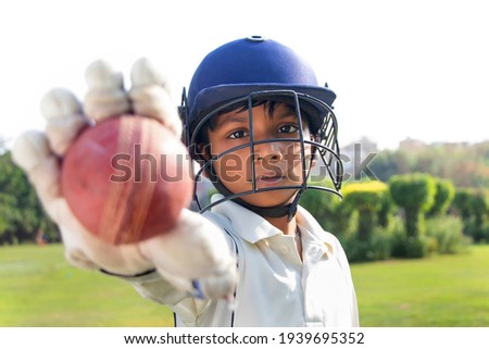 Portrait of boy wearing cricket helmet and Showing cricket ball Royalty-Free Stock Photo #1939695352