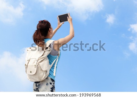 Happy woman traveler photo by tablet pc with blue sky
