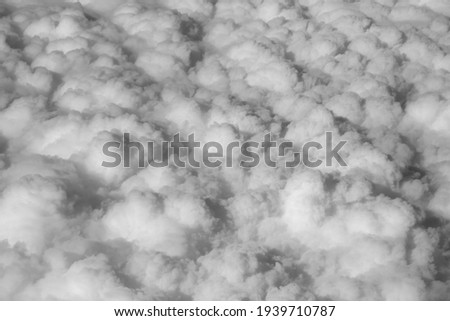 Stratosphere, a view of clouds from an airplane window. Black and white photo. Cumuliform cloudscape on sky.