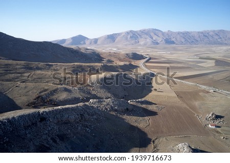 Mountain valley with farmlands and road. Countryside landscape.