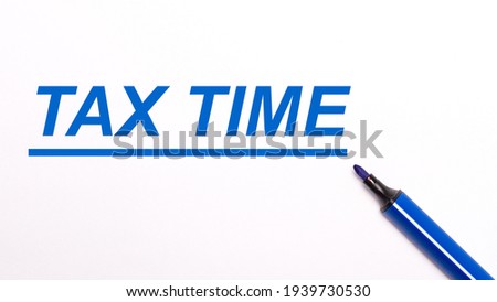 On a light background, an open blue felt-tip pen and the text TAX TIME