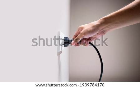 Hand connecting electrical plug cause electric shock, Idea for causes of home fire, Electric short circuit, Electrical hazard can ignite household items Royalty-Free Stock Photo #1939784170