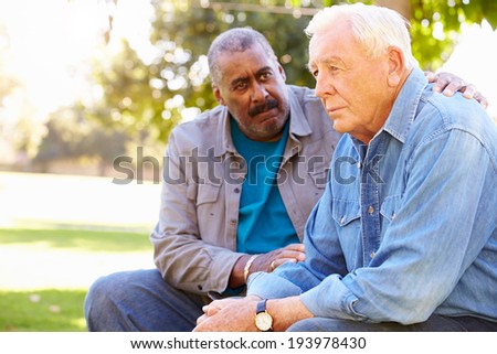 Man Comforting Unhappy Senior Friend Outdoors Royalty-Free Stock Photo #193978430