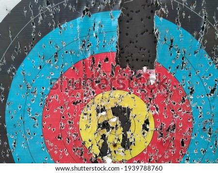 Archery target close up with many arrow holes in Gold, red, blue and black  Royalty-Free Stock Photo #1939788760