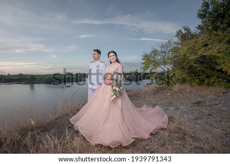 Asian couples happily take pre-wedding pictures with Thai suit and pink dress before getting married.