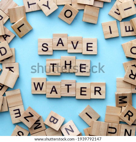 Save the water. Top view of wooden letters with blue background. Flat lay concept