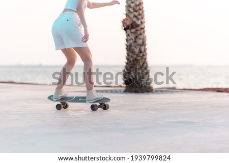 Close up rear view Asian women leg on surf skate or skate board in breach background Royalty-Free Stock Photo #1939799824
