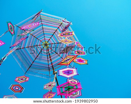 Colorful Thai traditional mobile hanging on blue sky as background. Cobweb shape made from bamboo and thread for good luck. Thailand Northeast celebrate ceremony. Thai handicraft art culture concept.