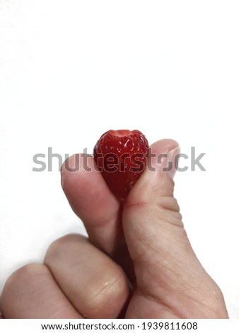 The strawberry in the hand made a mini heart represents sweet love.