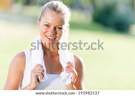 Young attractive sport girl in park with towel on neck