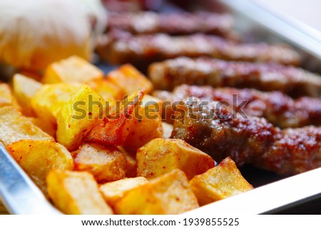 Traditional Serbian street food served in fastfood restaurant for dinner.Civapcici kebab meat and baked potato.Download royalty free curated images collection with foods for design template