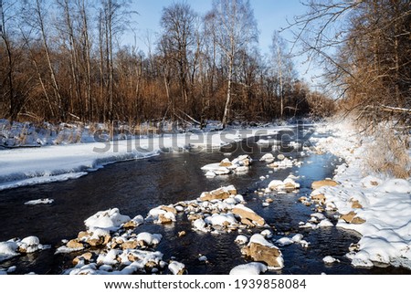 Sunny spring weather melts the ice on the river. the beauty of Russian nature. winter landscape. thawed the river. stones in the water are covered with snow. Sunshine morning