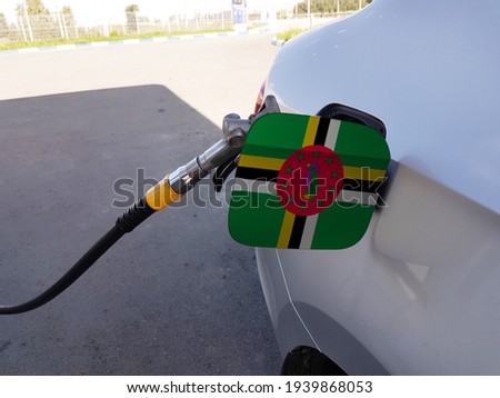 Flag of Dominica on the car's fuel tank filler flap. Petrol station. Fueling car at a gas station.