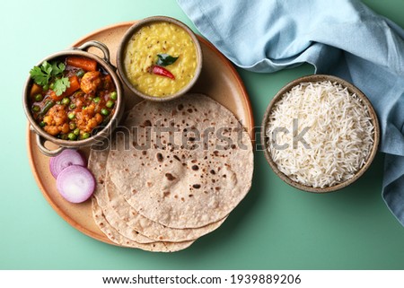 vegetarian Indian thali or Indian home food with lentil dal, cauliflower curry, roti or Indian flat bread and rice Royalty-Free Stock Photo #1939889206