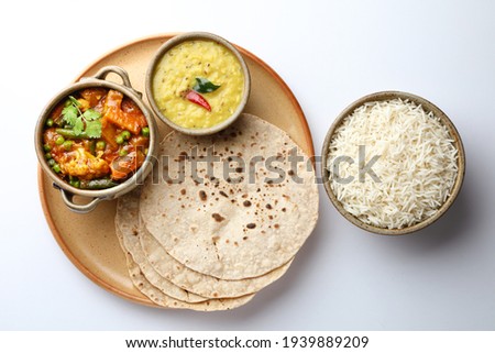 vegetarian Indian thali or Indian home food with lentil dal, cauliflower curry, roti or Indian flat bread and rice Royalty-Free Stock Photo #1939889209