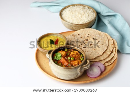 vegetarian Indian thali or Indian home food with lentil dal, cauliflower curry, roti or Indian flat bread and rice Royalty-Free Stock Photo #1939889269