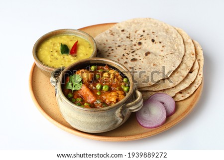 vegetarian Indian thali or Indian home food with lentil dal, cauliflower curry, roti or Indian flat bread and rice Royalty-Free Stock Photo #1939889272