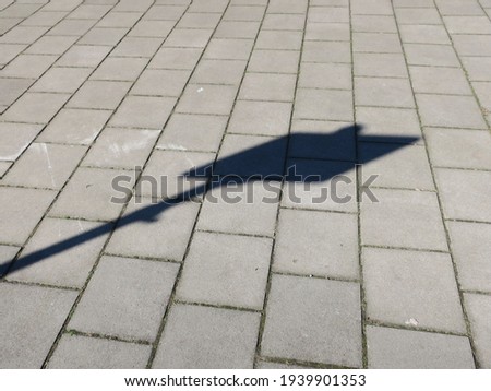 the shadow of a sign in the sidewalk on a sunny day