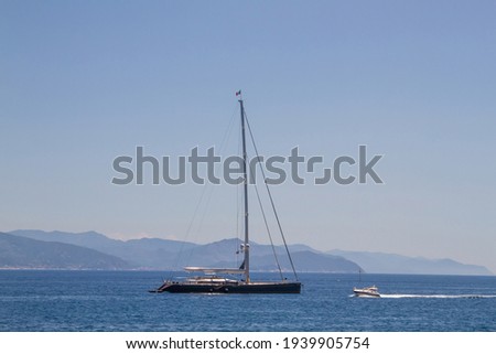 Yachts at sea against the backdrop of the outlines of the mountains.